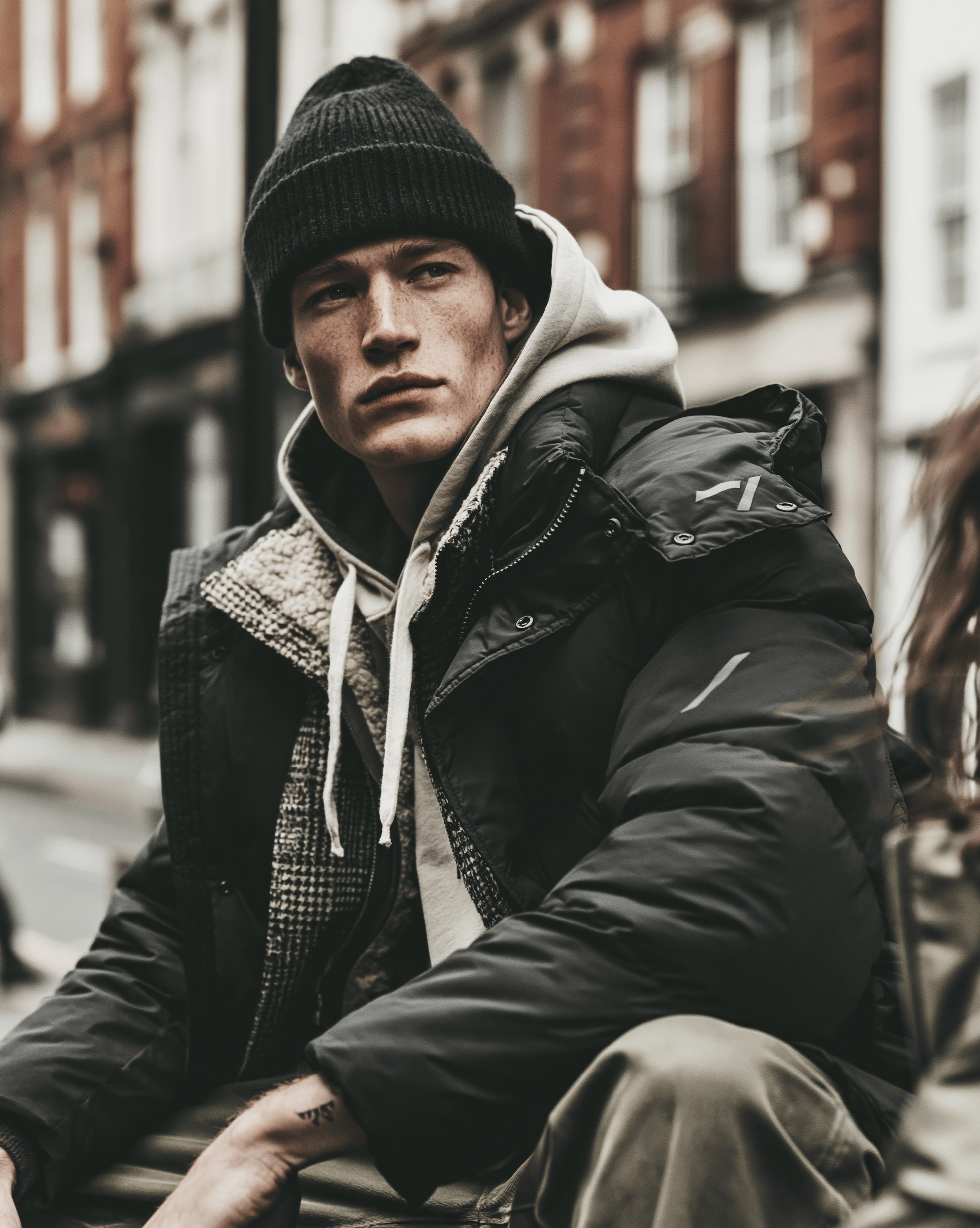 Studio ARTVÉA Outerwear & Layering mit hochwertiger Puffer-Jacke, Hoodie-Layering und dezentem Branding für moderne Corporate Fashion und Brand Apparel Konzepte.