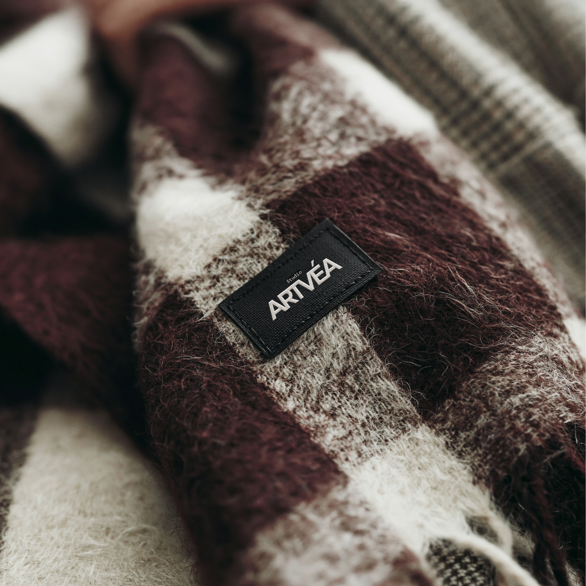 Detailaufnahme eines Wollschals mit gewebtem Studio ARTVÉA Label als hochwertiger textiler Brand Touchpoint.
