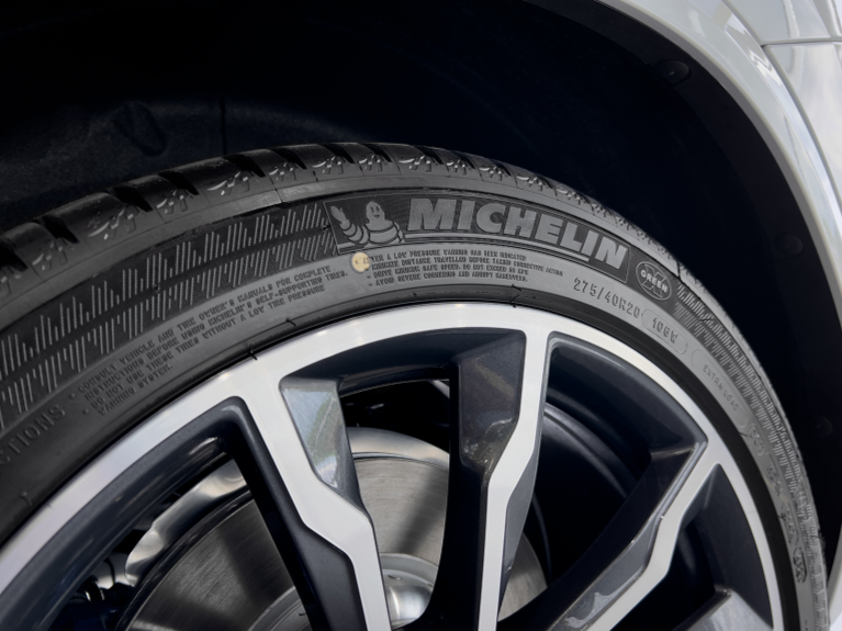 Close-up of a car tire and alloy wheel, with the Michelin brand name visible on the tire.
