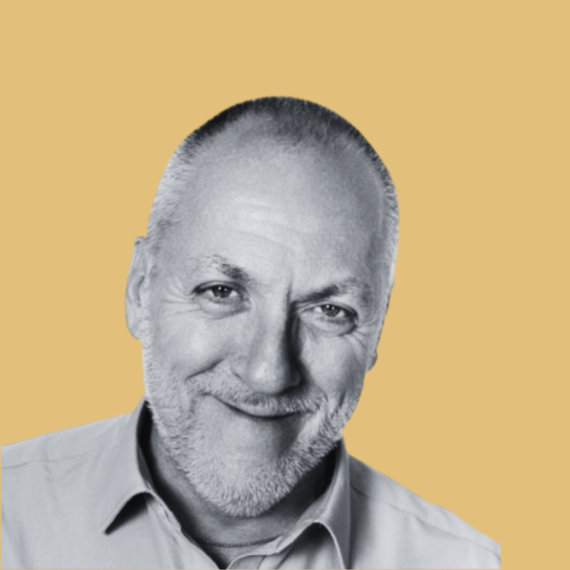 Black and white portrait of a smiling middle-aged man with a beard and short hair, wearing a collared shirt, against a yellow background.