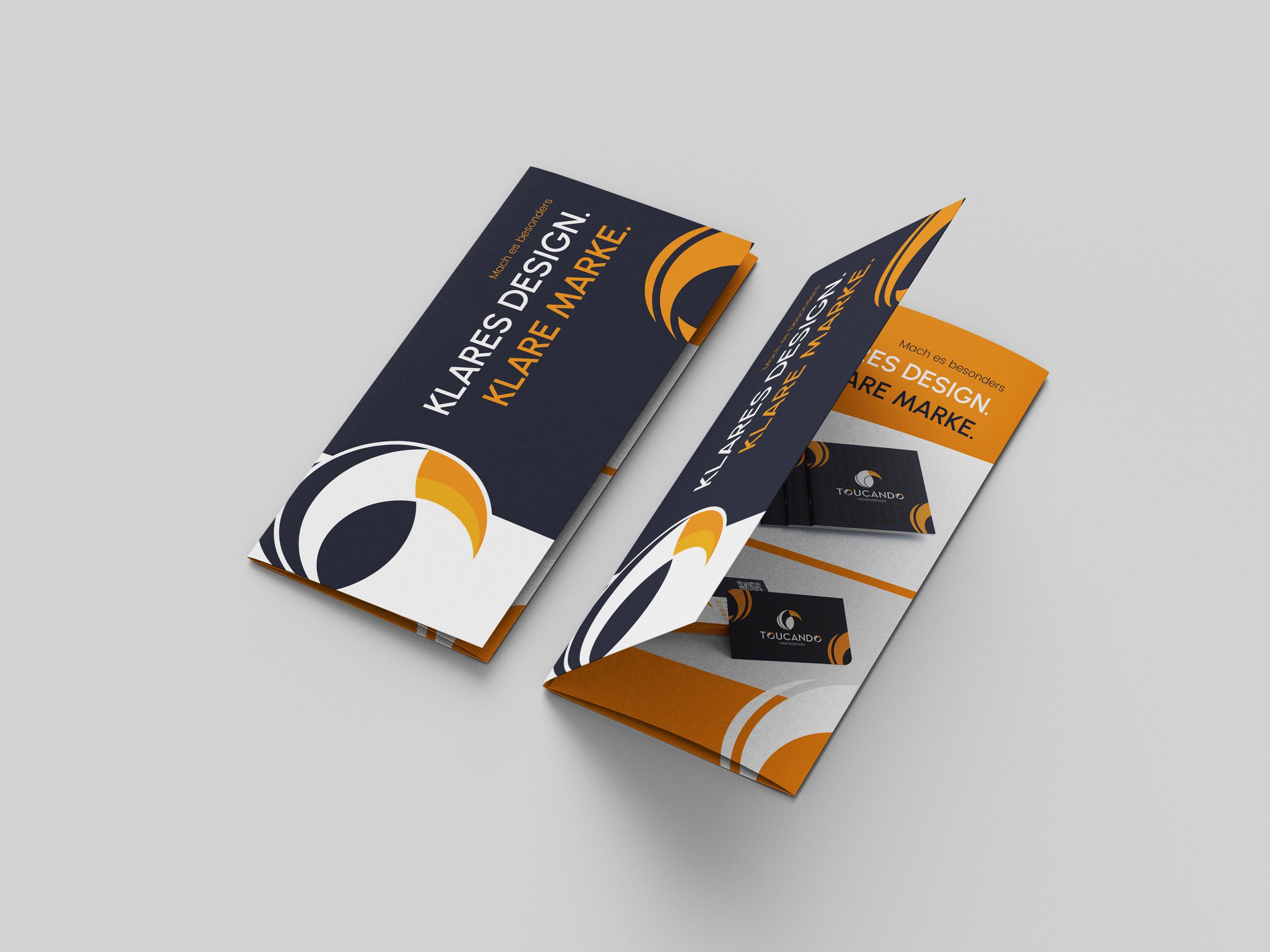 Drei Flyer in Dunkelblau, Weiß und Orange, werbend für Marken-Design, zeigt einen stilisierten Vogelkopf und textbasierte Gestaltung.