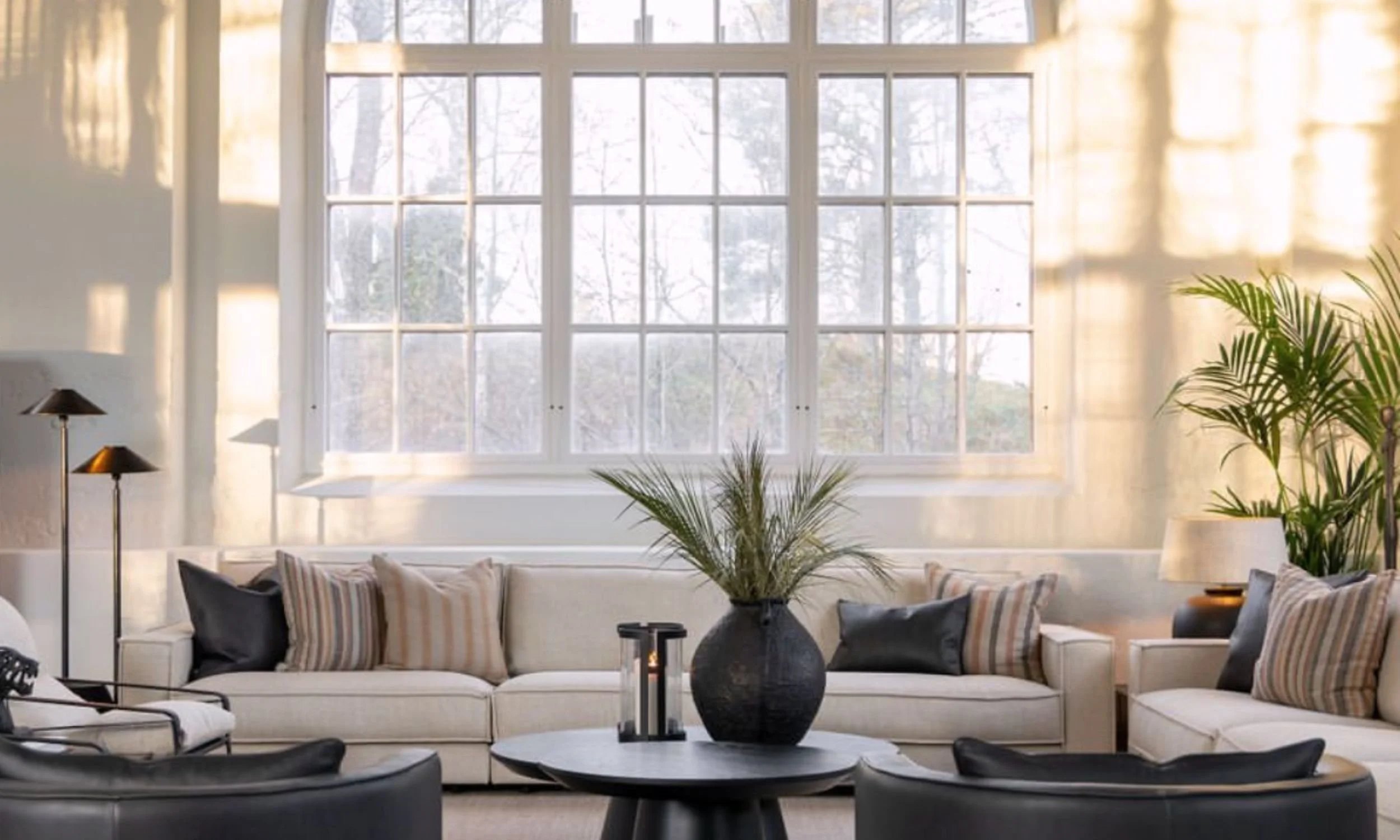 En vakker stue stylet av Artwood med store vinduer som slipper inn vakkert lys.