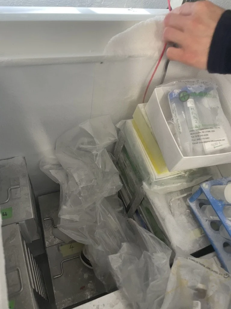 Arbeitsbereich in einem Labor mit medizinischen Verpackungen, Plastiktüten und Geräten, die in einem klinischen Umfeld verwendet werden.