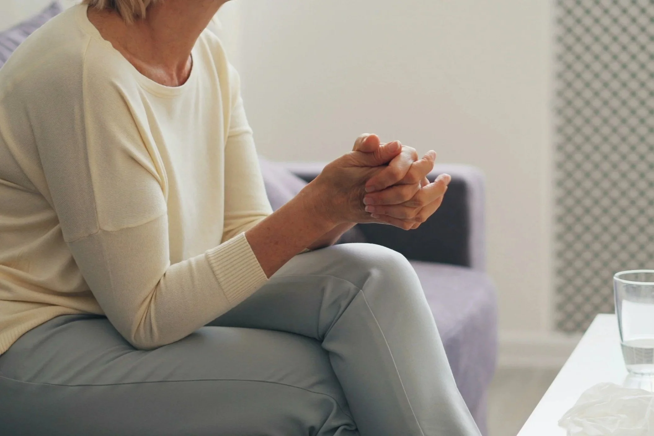 A woman sitting comfortably on a sofa during a consultation for bladder control, bowel management, and pelvic organ prolapse therapy.