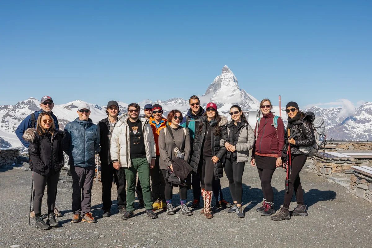 Group of hikers in snowy mountain landscape with Matterhorn peak in the background.