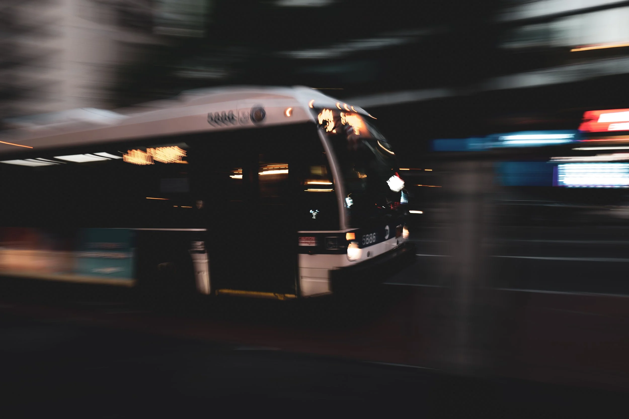 A moving train in a dark setting with motion blur, featuring bright reflections and LED lights.