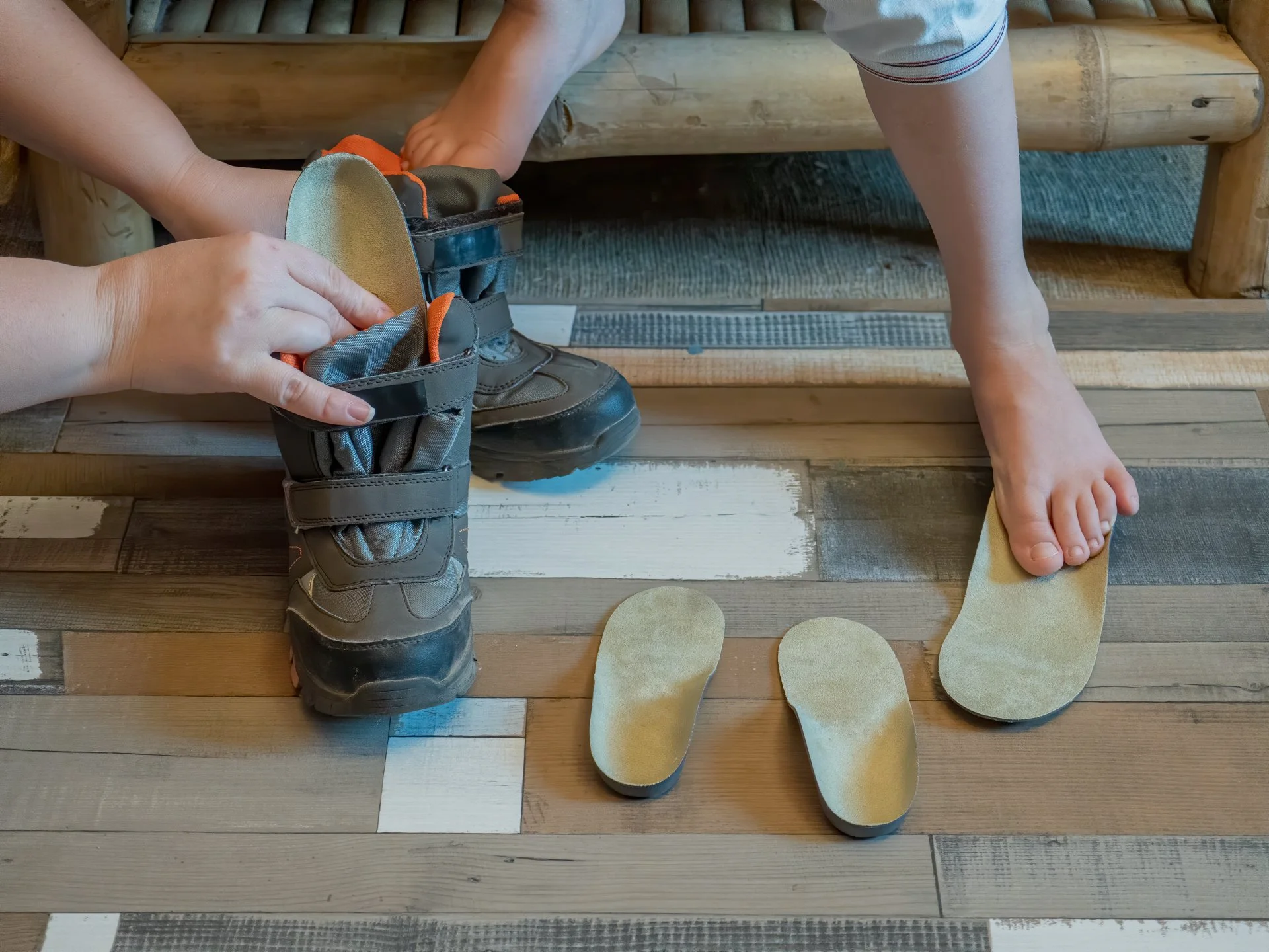 Orthopädieschuhmacher legt maßgefertigte Einlegesohlen in Kinderschuhe ein – orthopädische Versorgung für gesunde Kinderfüße