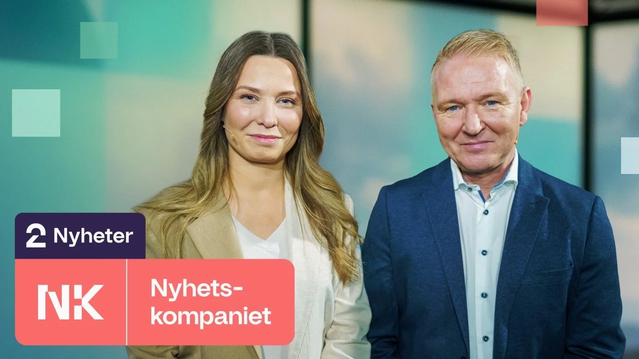 A woman and a man standing together, both smiling, against a colorful background with news graphics and logos for NRK Nyheter and Nyhetskompaniet.