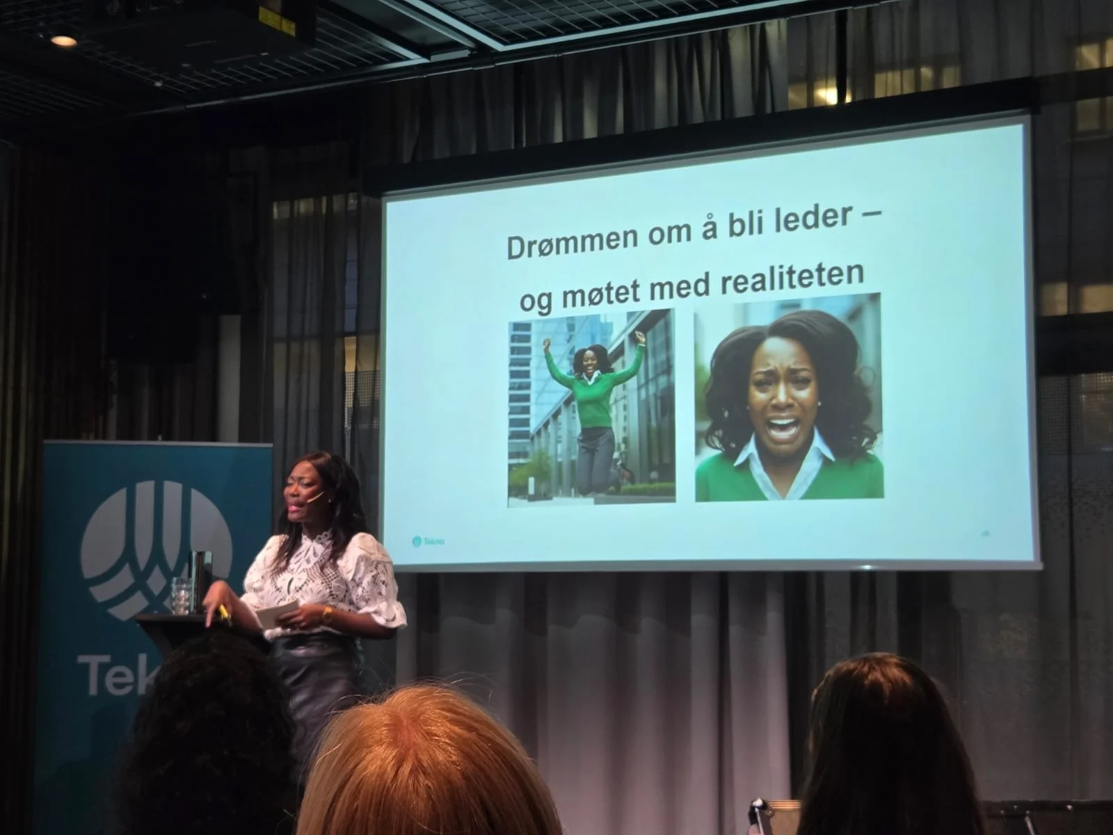 A woman on stage giving a presentation at a conference, with a large screen behind her displaying a slide in Norwegian. The slide shows two images of women in green clothing and the text 'Drømmen om å bli leder - og møtet med realiteten'.