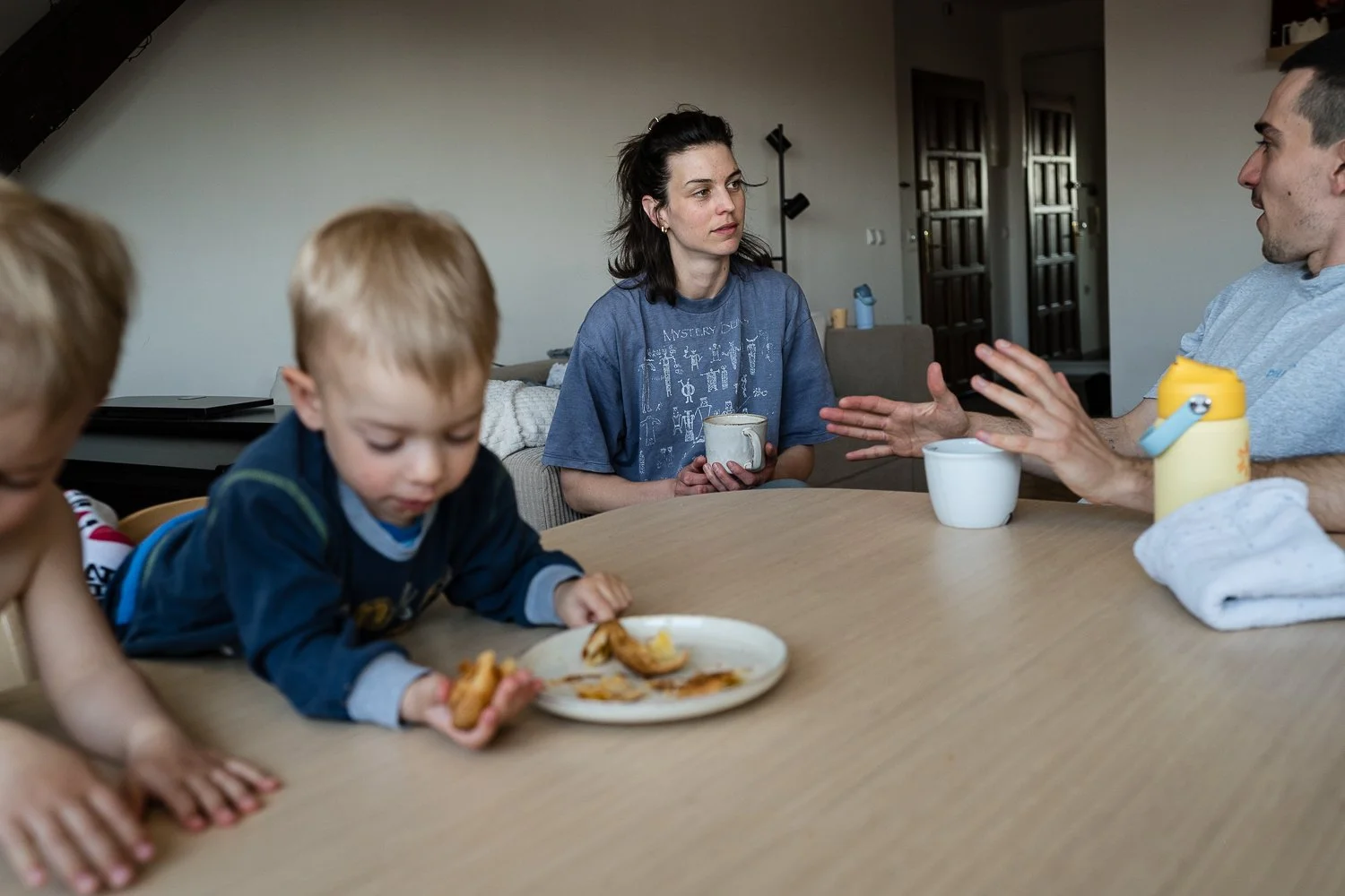 Štiričlanska družina, mama Lea Mihevc, oče Petja pijeta kavo in jesta rogljičke.