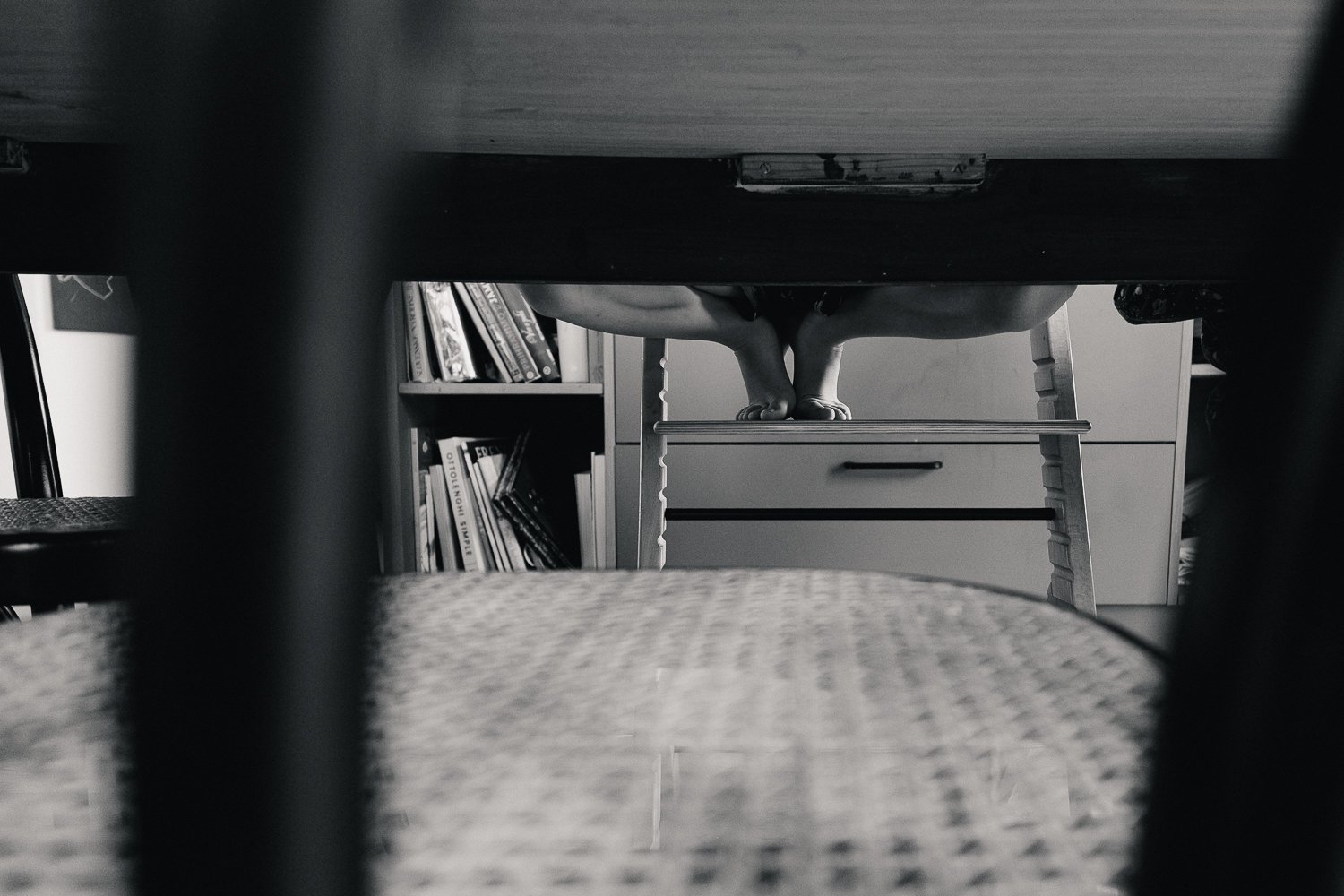 družinsko fotografiranje zgodnje jutri otrok sedi na triptrap stolu in ima bose noge