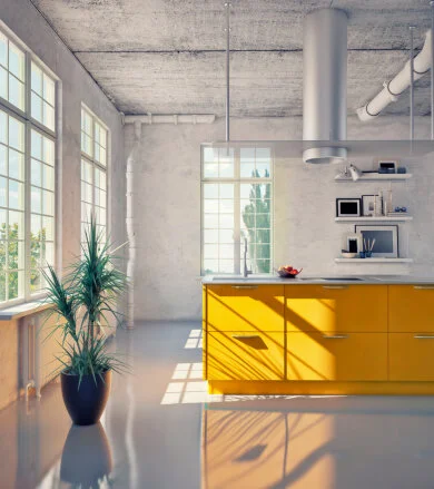 Modern kitchen with yellow cabinets, large windows letting in natural light, a potted plant, and white walls with shelves and appliances.