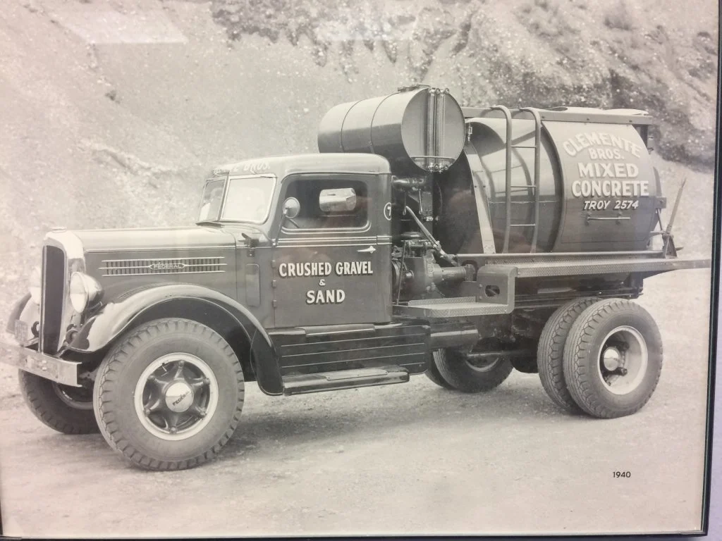 Black and white photo of a vintage cement mixer truck from 1940 with signage for Clemente Bros. mixed concrete and crushed gravel and sand