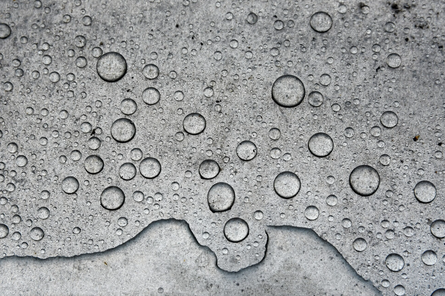 Close-up of water droplets on a gray surface.