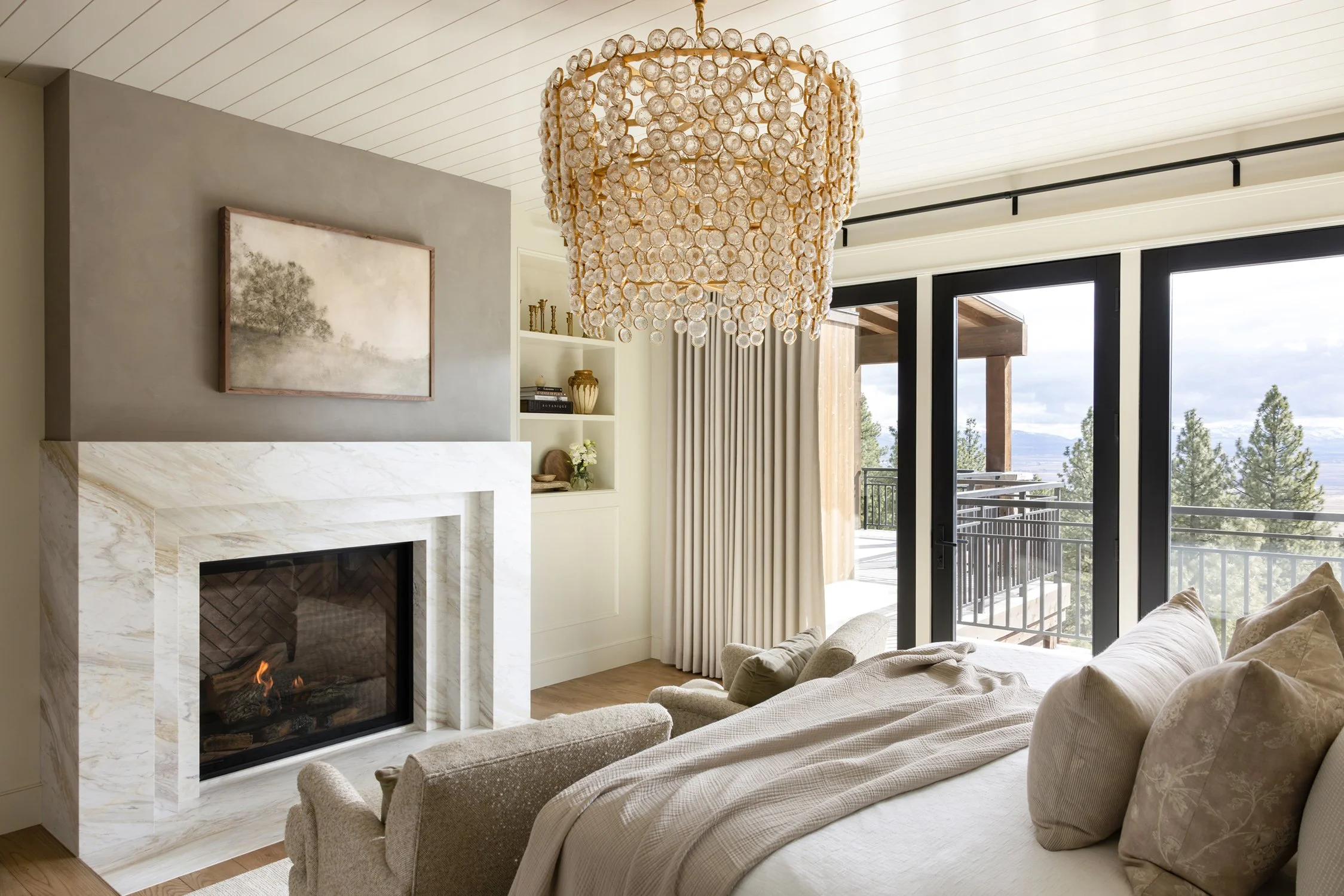 bedroom with fireplace, balcony, and chandelier