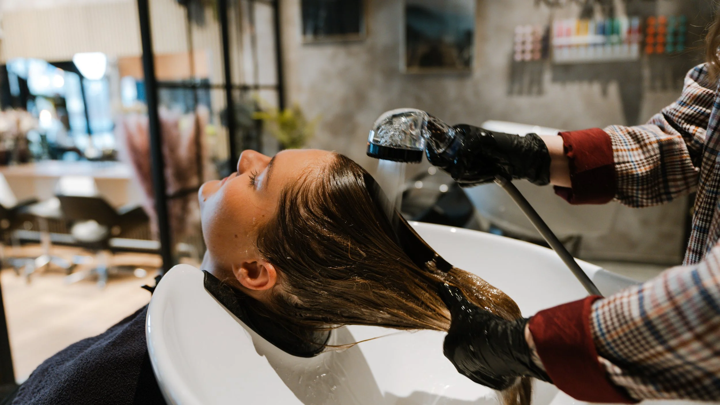 En person får vasket deres lange hår i en frisør- eller salonopstilling.