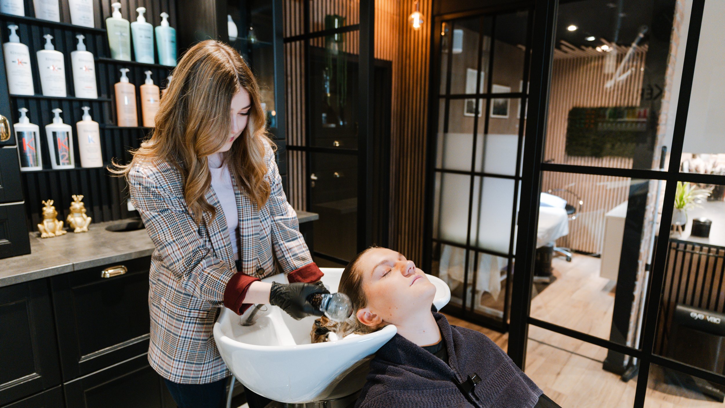 En frisør vasker en kundes hår i en frisørsalon.