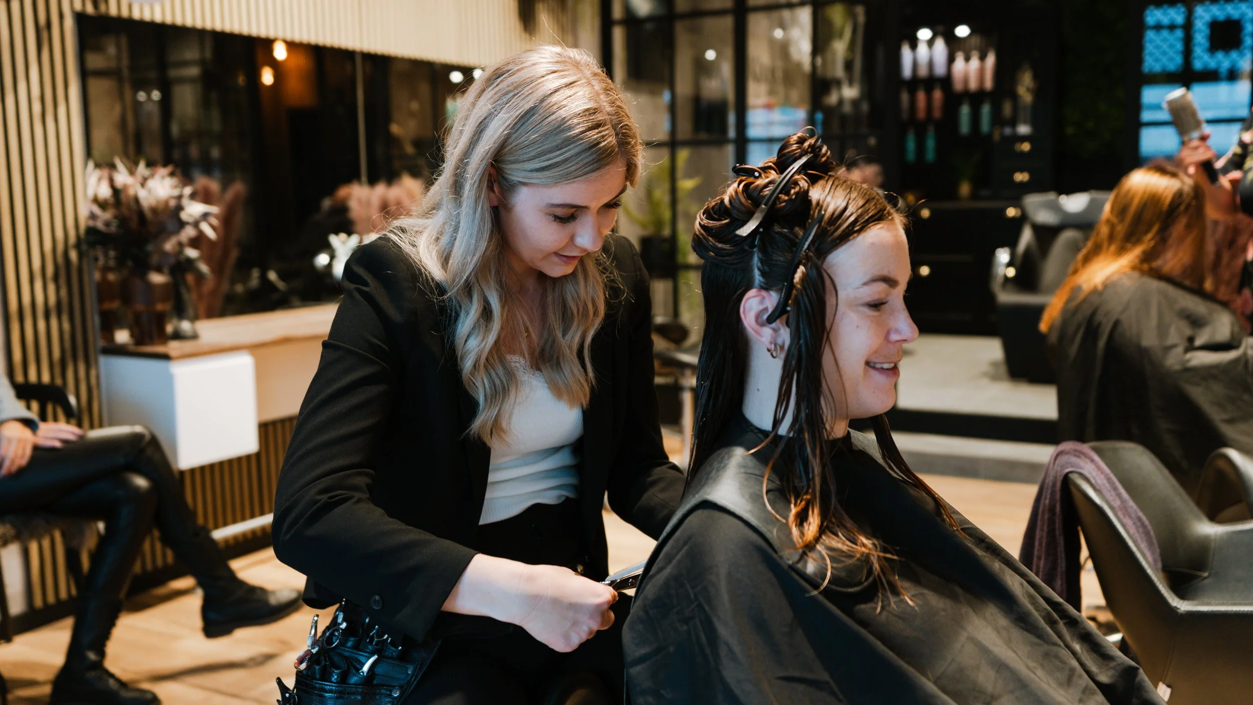 En frisør hjælper en kvinde med at få farvet hår i en salon.