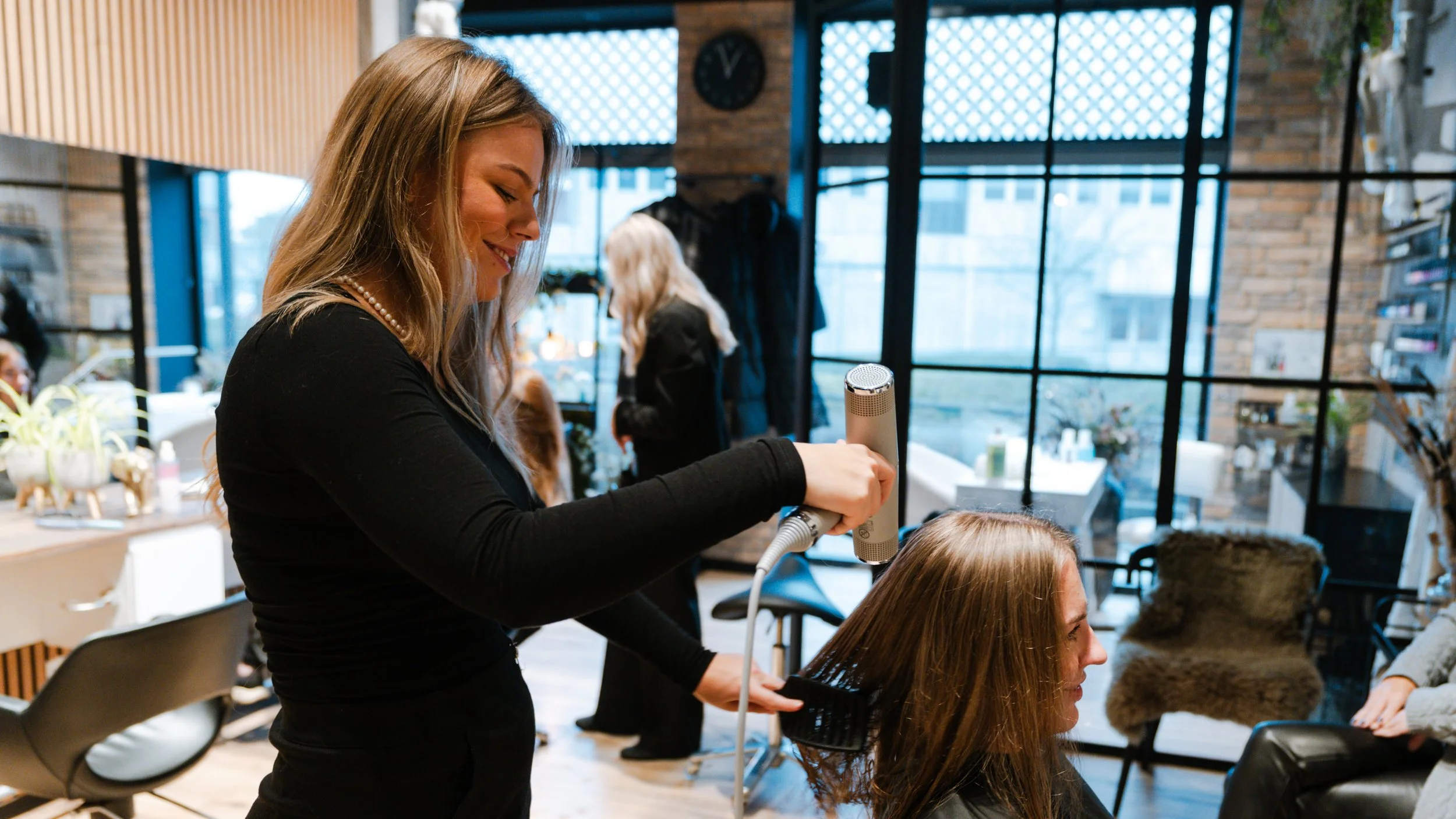 Kvinde får sit hår føntørret i en frisørsalon.