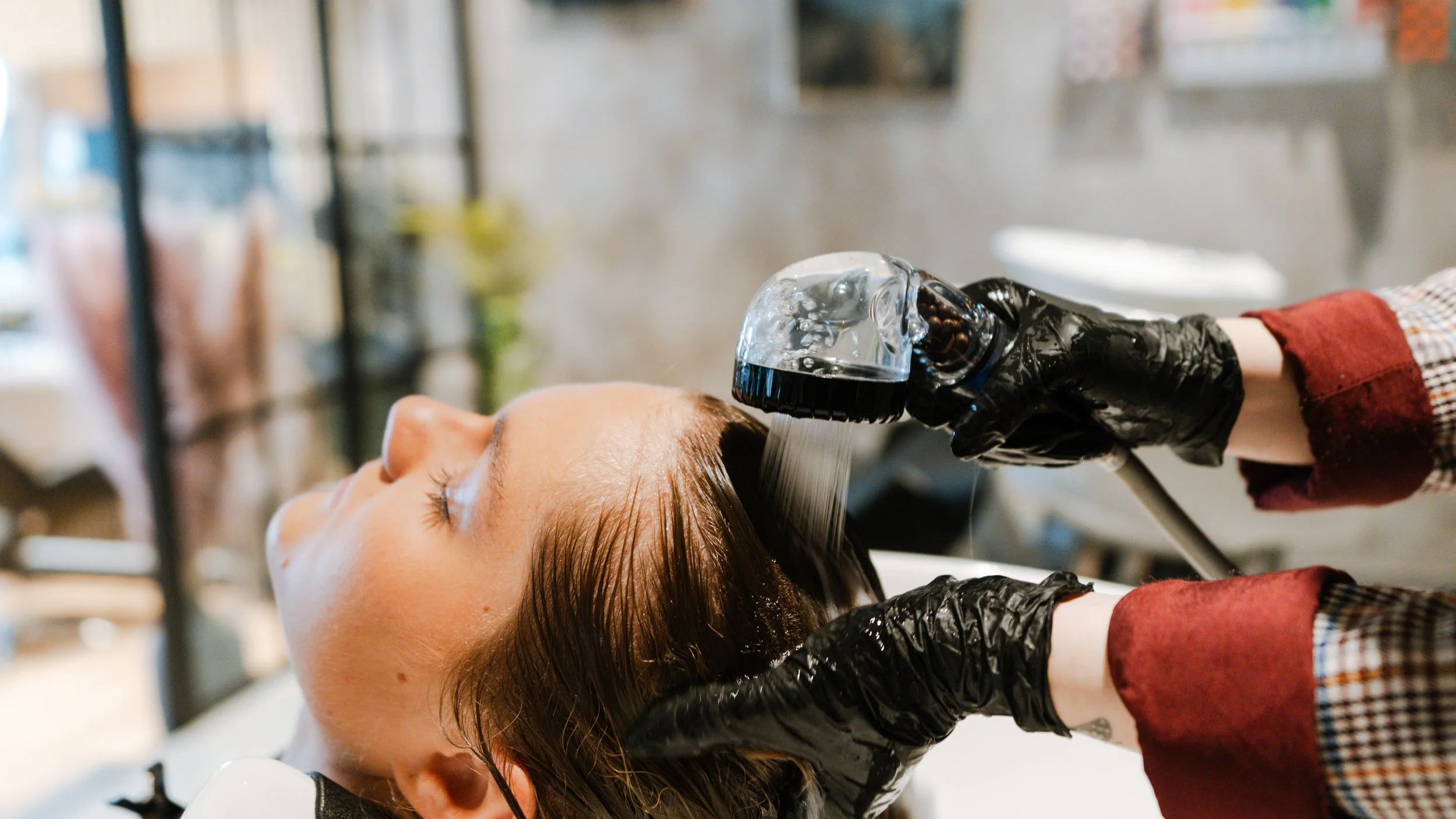 Kvinde får vasket sit hår på en frisørsalon.