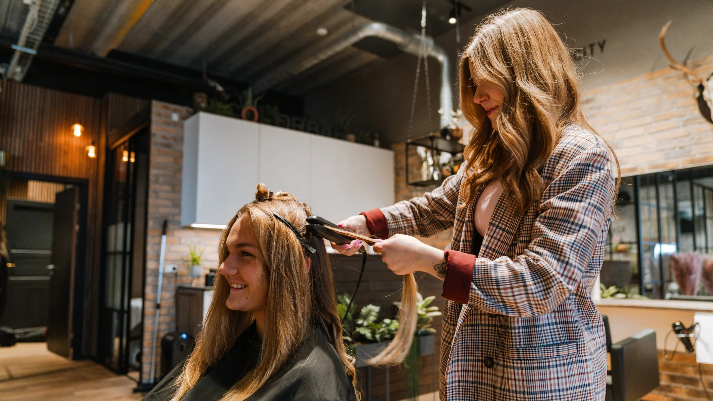 En frisør klipper en kvindes hår i en moderne salon.