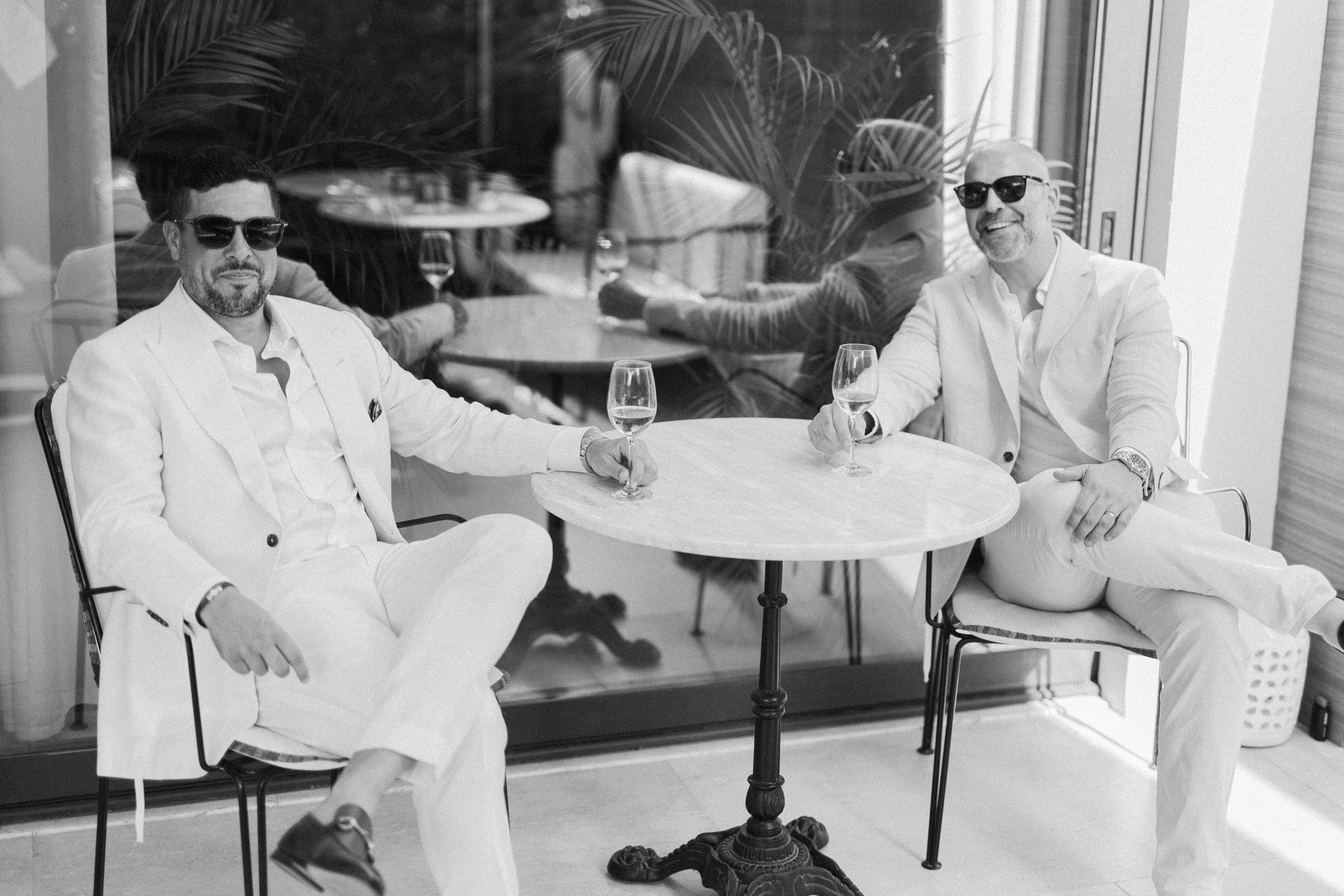 Groom and best man editorial cocktail hour Lake Vouliagmeni Athens Greece wedding