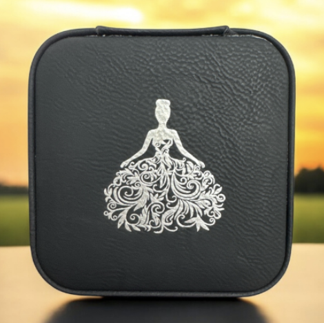 A black square case with a white illustration of a woman in a fancy dress on it, set against a sunset background.