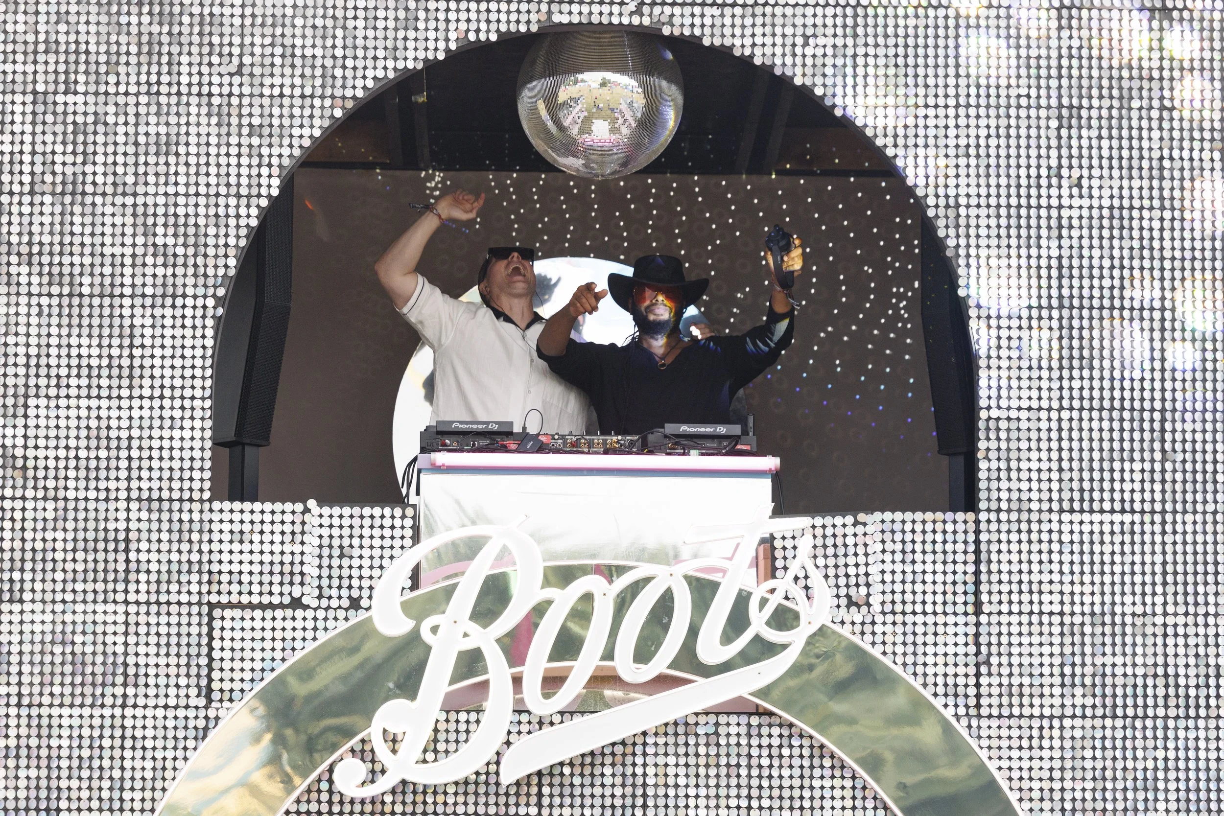 Two DJs performing on stage underneath a disco ball  at the Boots Beauty Box 2026