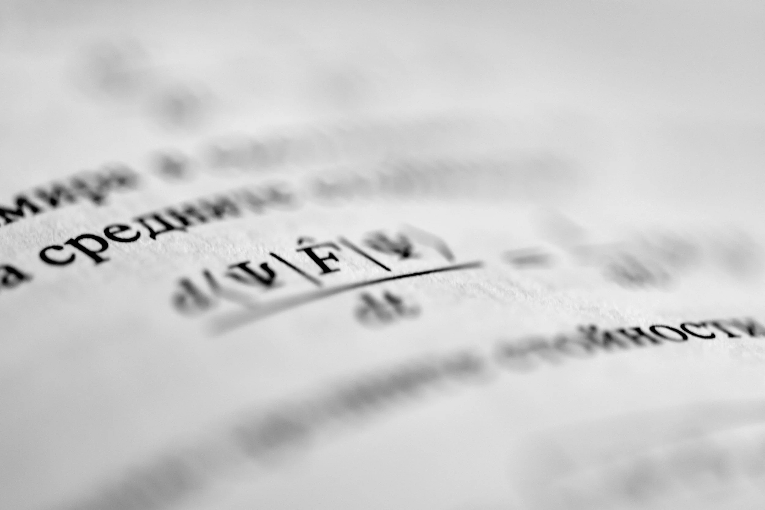 Close-up of printed text on paper, with some words in focus and others blurred.