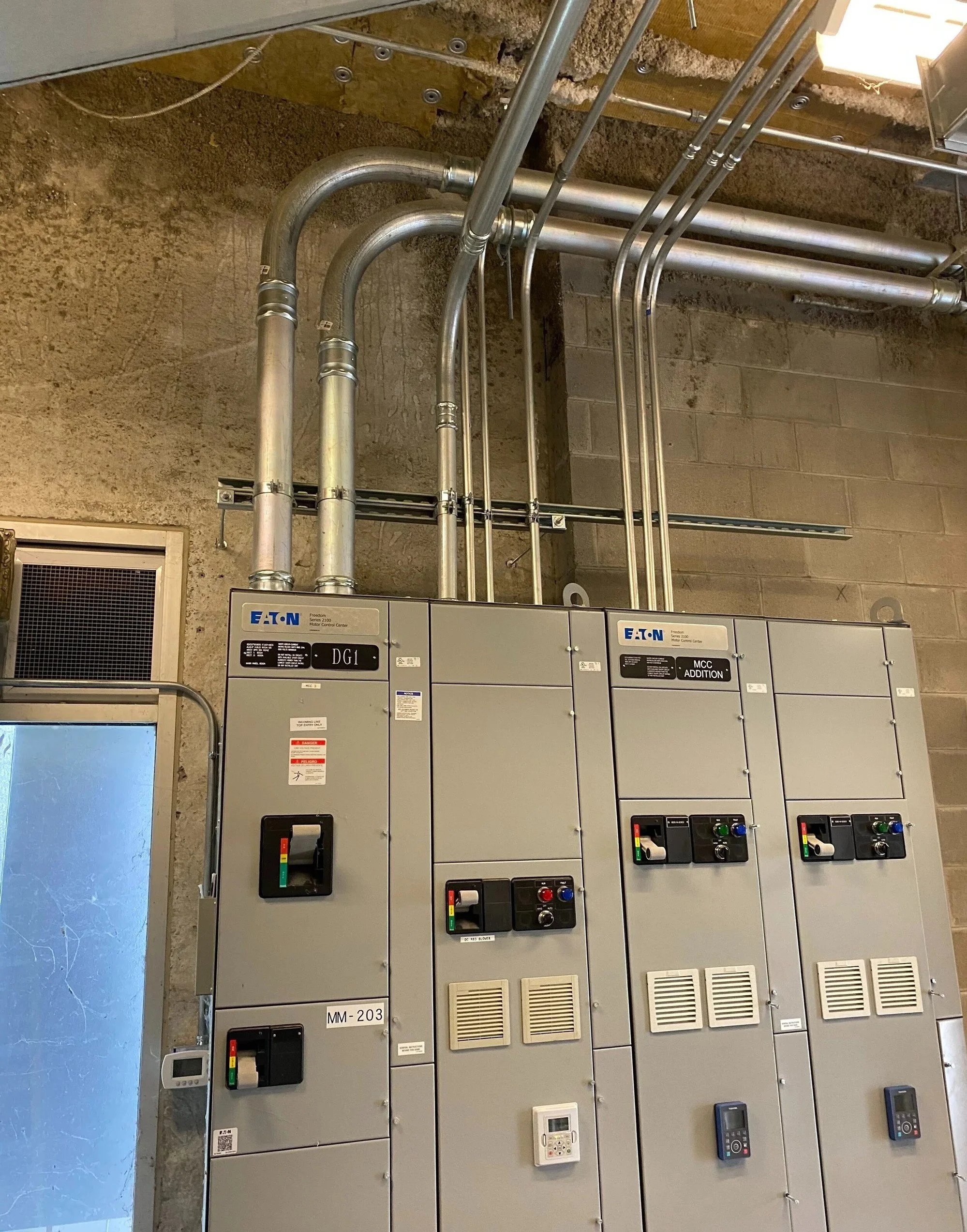 Electrical control panels with switches and vents in an industrial setting.