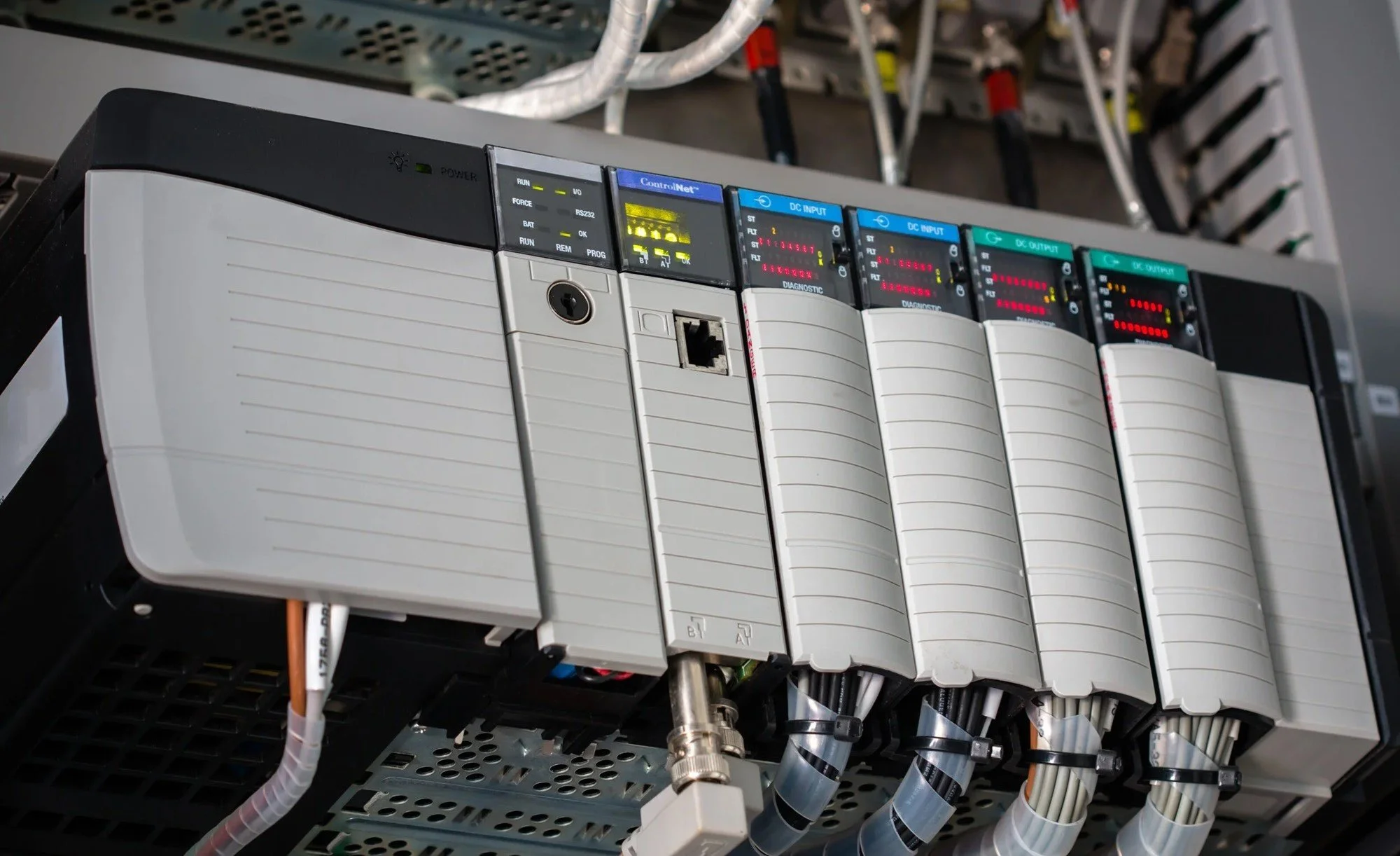 Industrial control panel with multiple colored digital displays and connected wires.