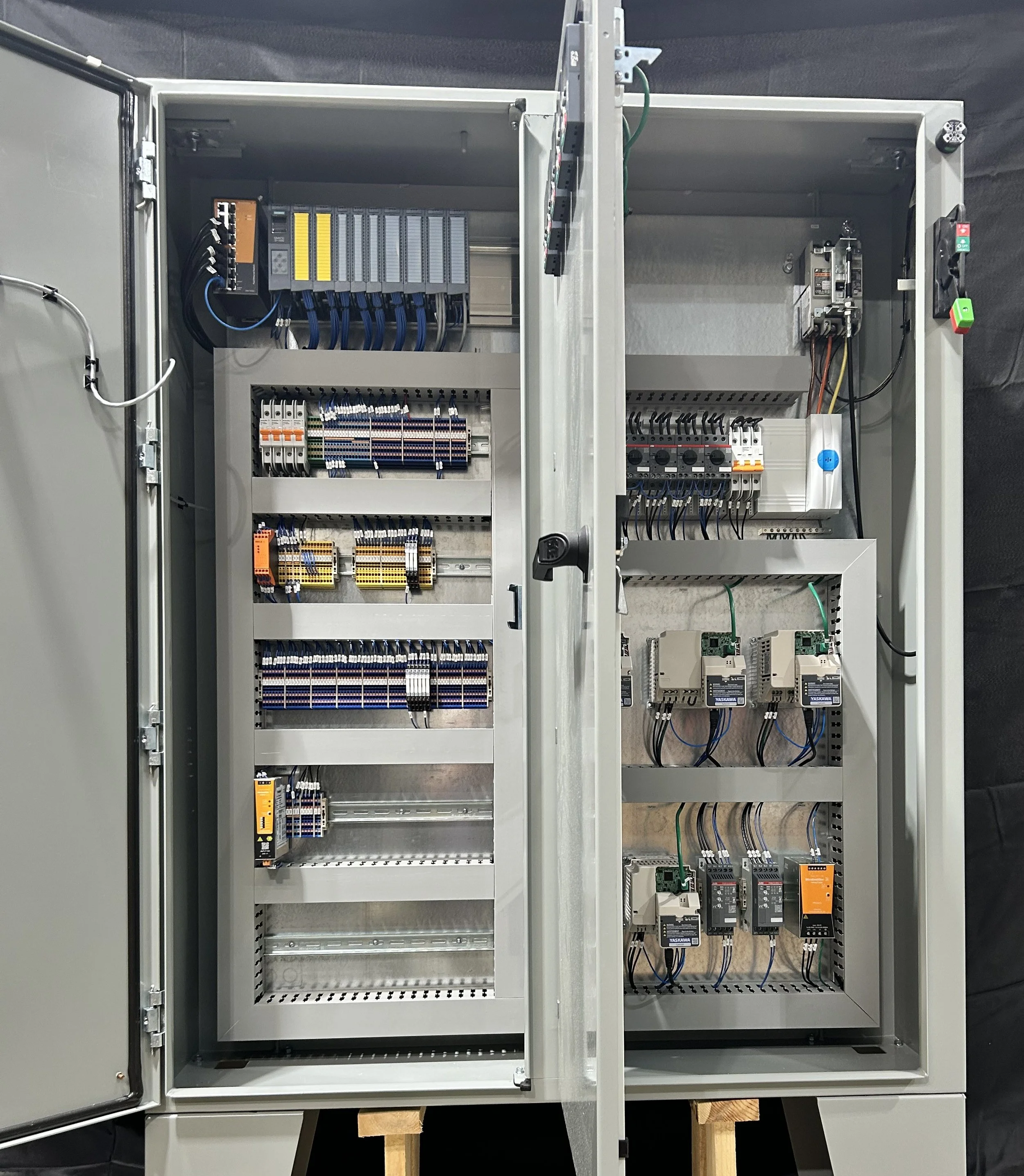 Open electrical control cabinet containing various circuit boards, wiring, and electrical components.