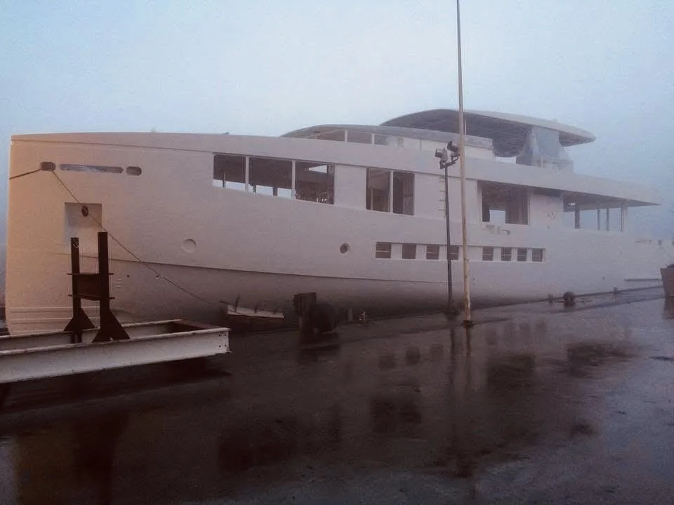 Large white boat or yacht on a dock during overcast weather.