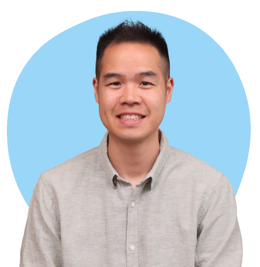 Portrait of a smiling man, founder of Oasis of Hope, Calvin Lam, with short black hair wearing a light gray button-up shirt against a modern blue abstract background.