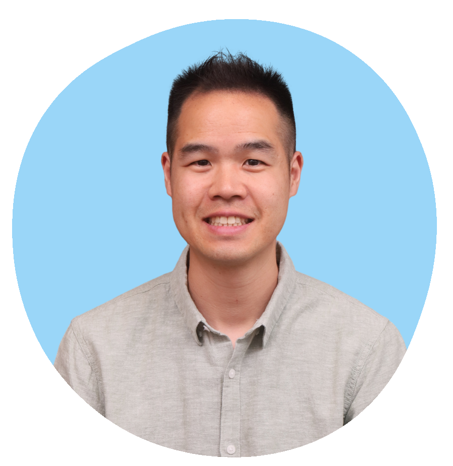 Portrait of a smiling man, founder of Oasis of Hope, Calvin Lam, with short black hair wearing a light grey button-up shirt against a modern blue abstract background.