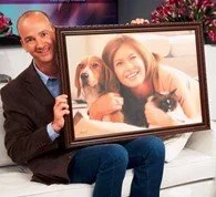 Man holding photo frame with a woman and their dogs inside