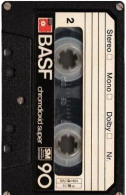 Close-up of a BASF audio cassette tape with labels for stereo and mono, and checkboxes for Dolby and NR, placed on a black surface.