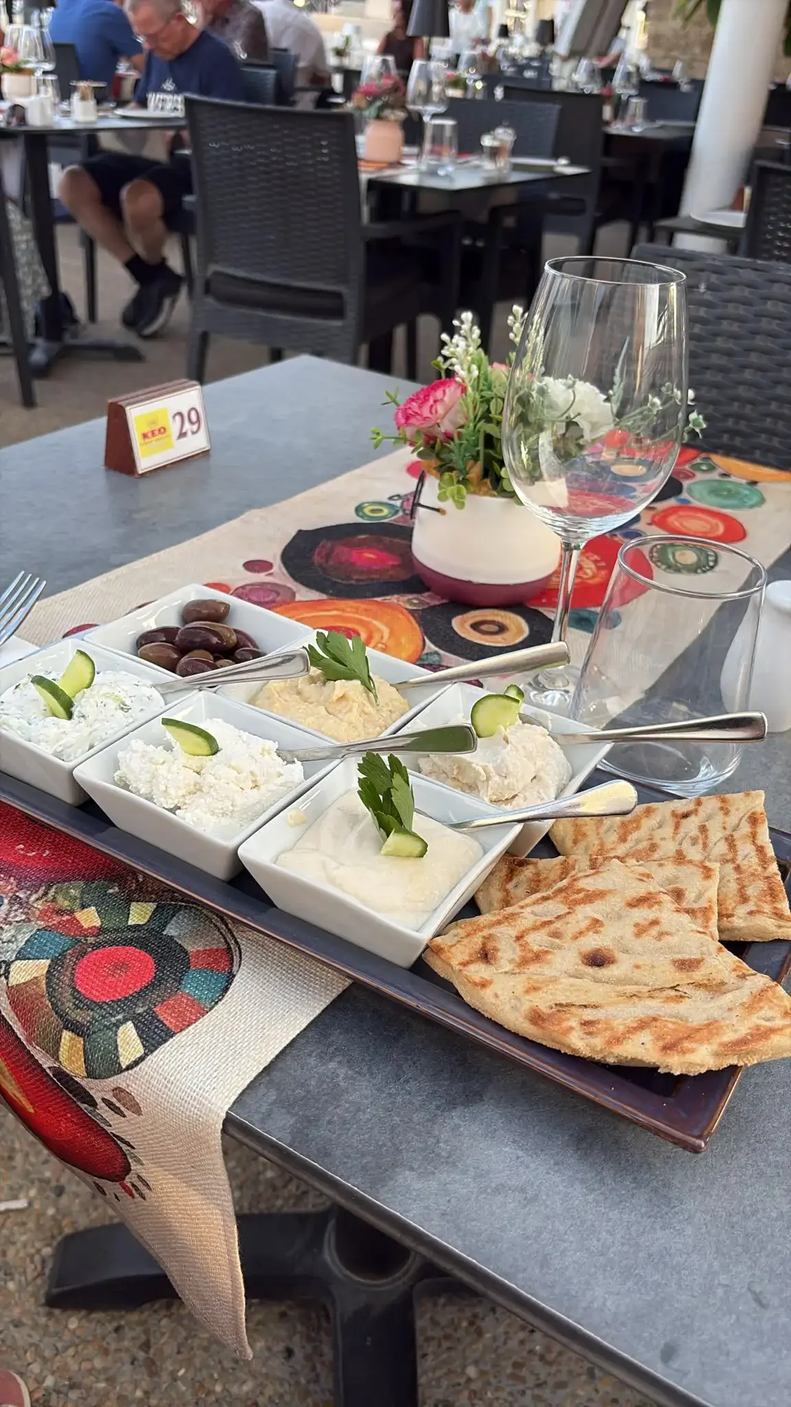 Assortiment de dips chypriotes servis en petits bols avec olives et pitas grillées, dans une taverne de Paphos