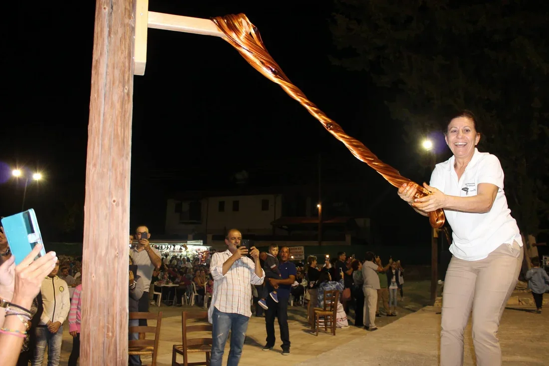 Fabrication traditionnelle du pastelli au festival d’Anogyra, le caramel de caroube étiré à la main sur un mât en bois