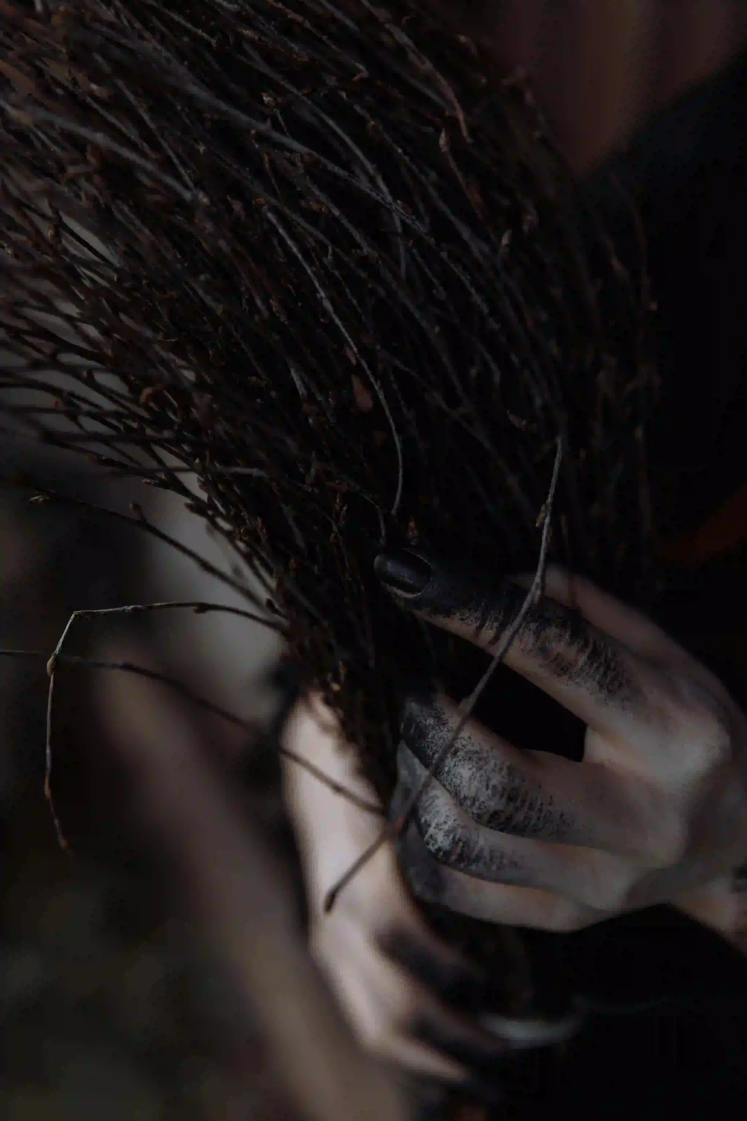 Main tenant un balai, symbole de protection contre la Ianara dans le folklore ischitain