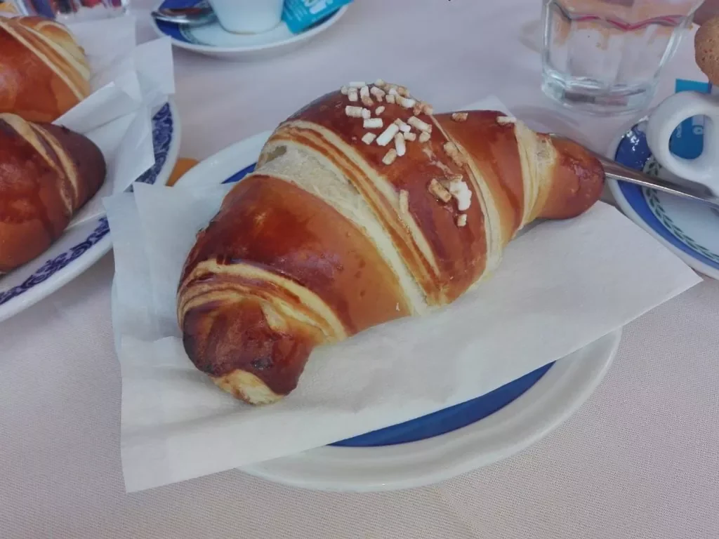 Cornetto ischitano garni de crème pâtissière, servi au café à Casamicciola, Ischia
