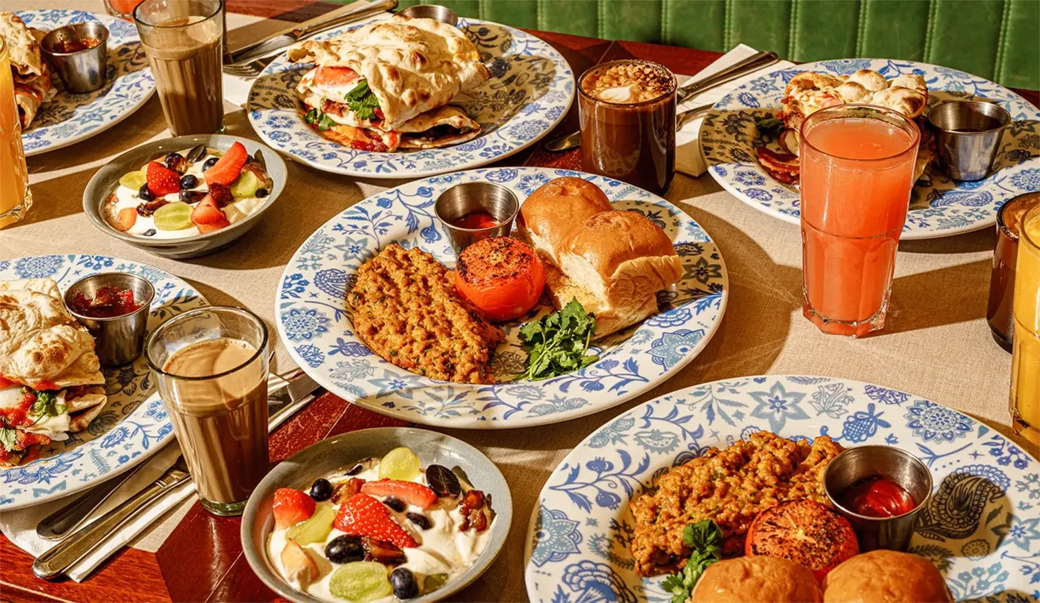 Table de brunch chez Dishoom à Édimbourg avec bacon naan roll, œufs épicés et chai