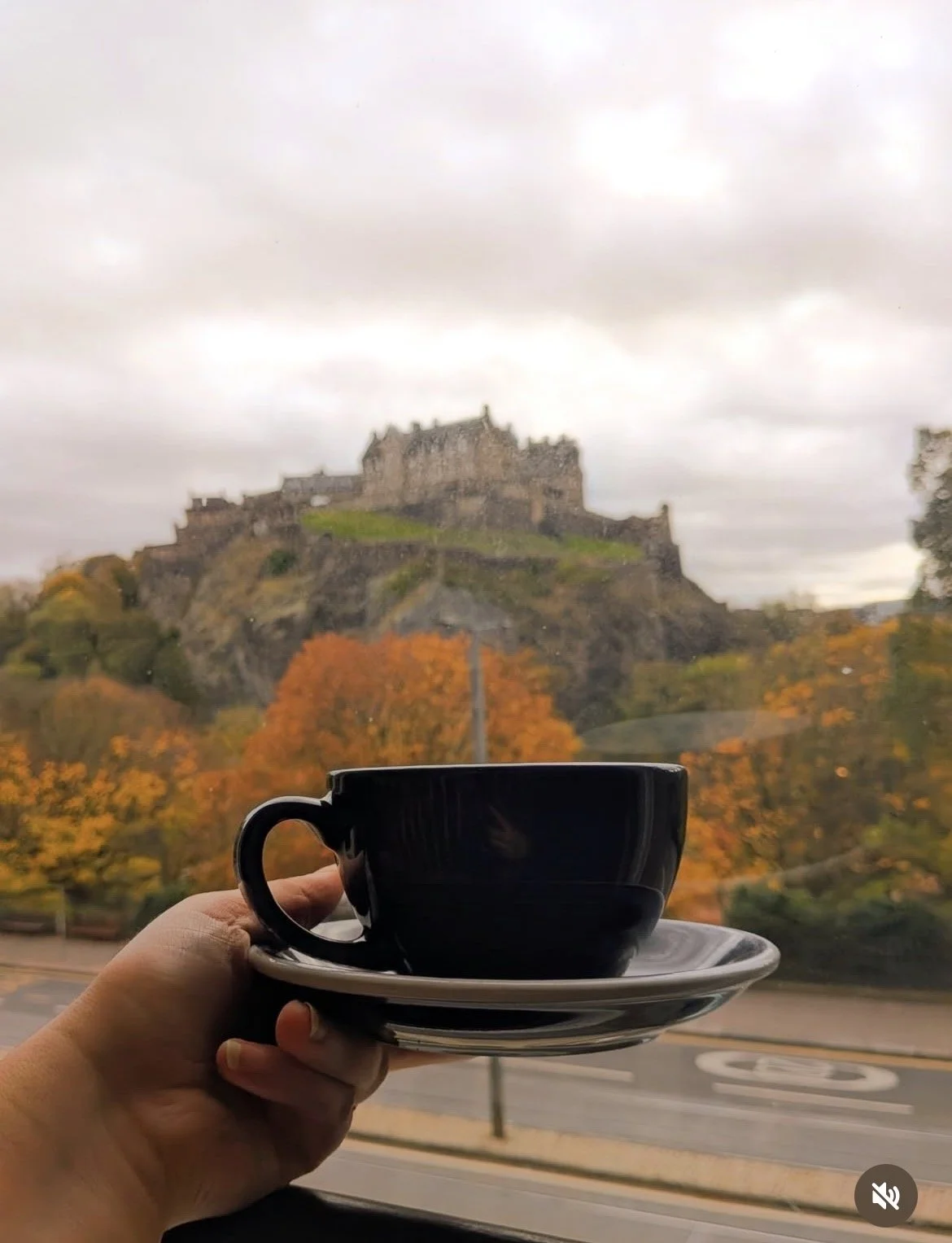 Tasse tenue à la main devant la fenêtre, chateau d'Edimbourg en arriere plan