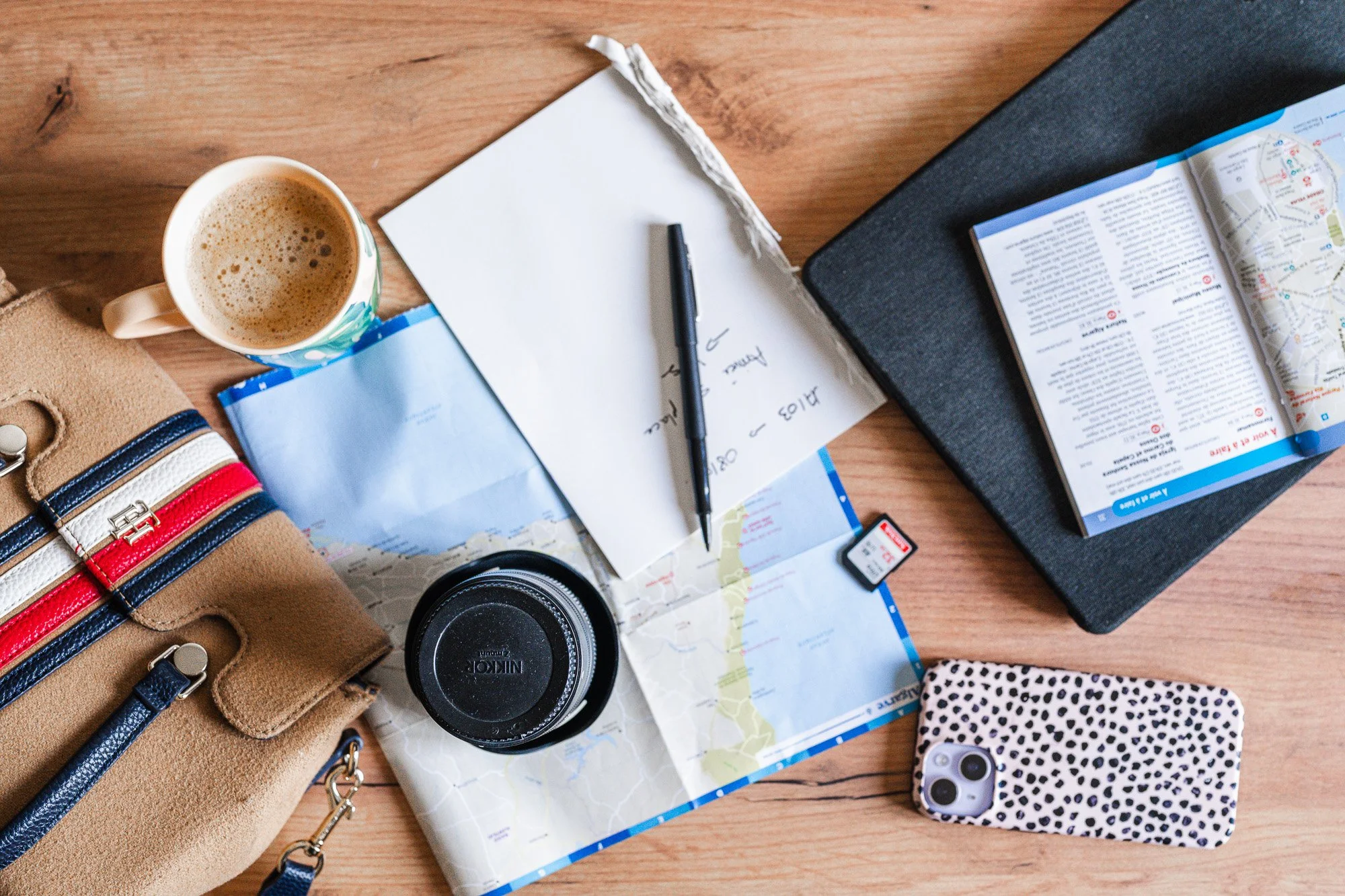 Vue du dessus, une table avec une carte, un carnet, et différents éléments pour préparer le voyage