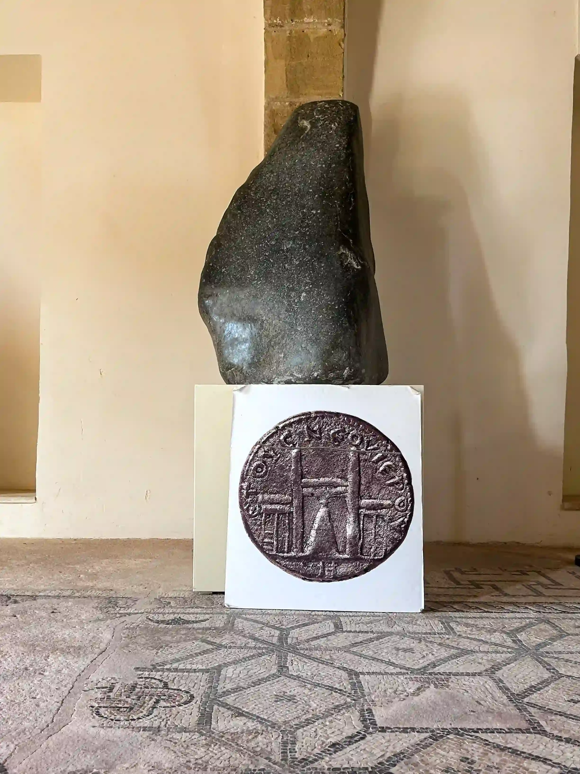 Pierre conique noire (bétyle) représentant Aphrodite, exposée au musée du sanctuaire de Palaepaphos à Chypre