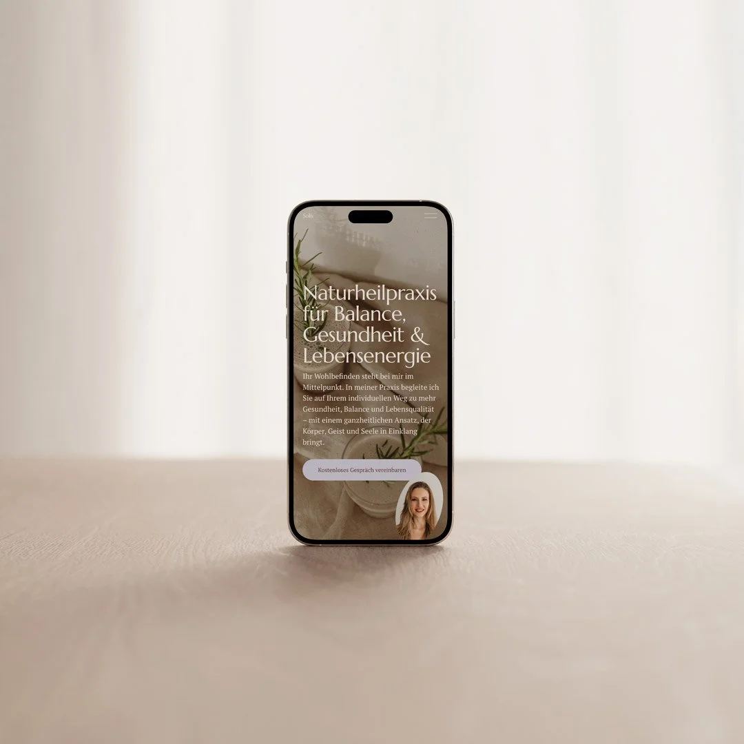 Smartphone zeigt Website einer Naturheilpraxis mit Text und einem Frauenporträt.