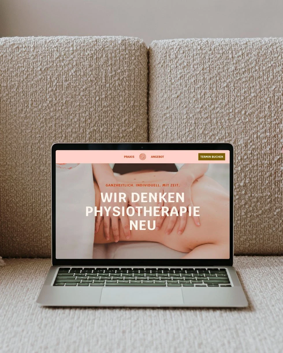 Laptop auf einem beige/grau Stoffsofa, Bildschirm zeigt eine Webseite für Physiotherapie mit einem Bild eines Massagetherapeuten an einem Rücken.
