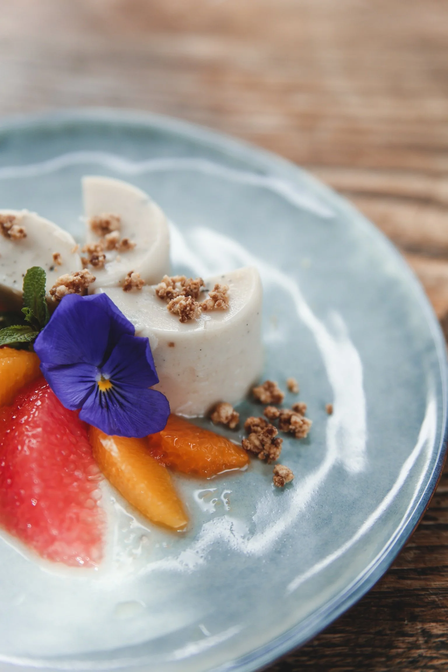 Dessert con panna, frutta fresca e fiori viola