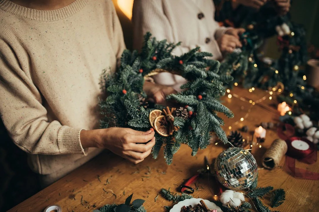 two women making christmas wreaths