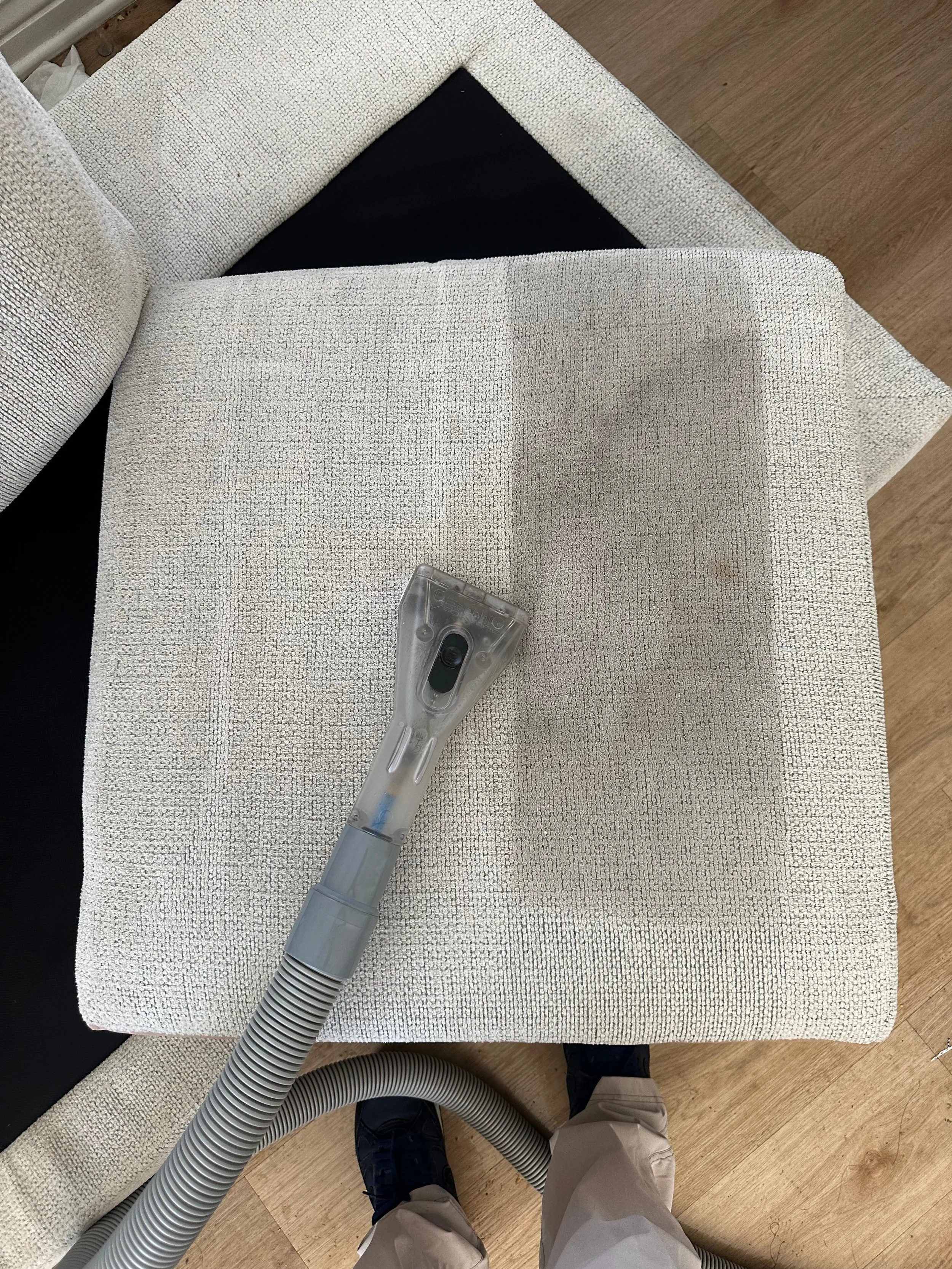 Yellow upholstered armchair with a small vacuum cleaner resting on its seat.